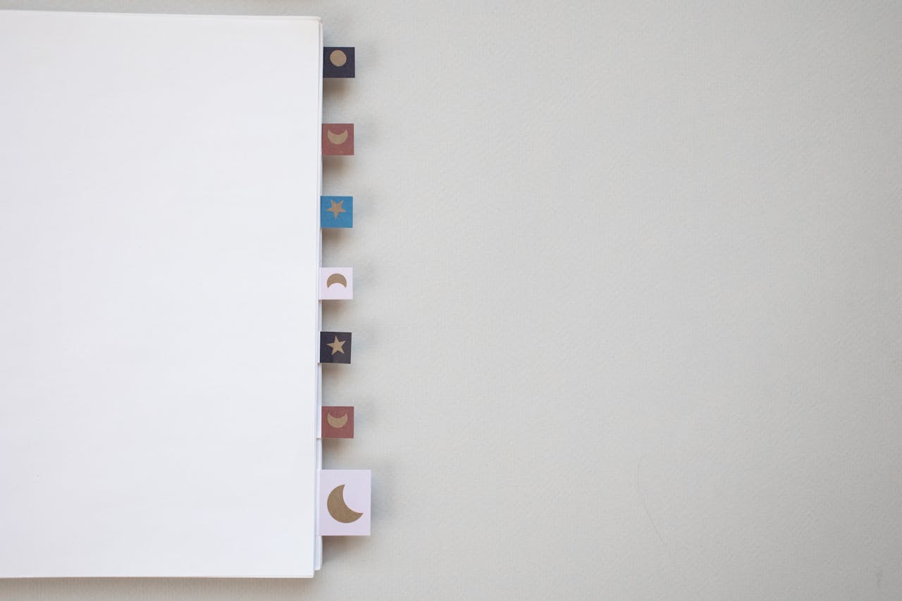 Open notebook with celestial-themed tabs against a light background, ideal for designers and educators.